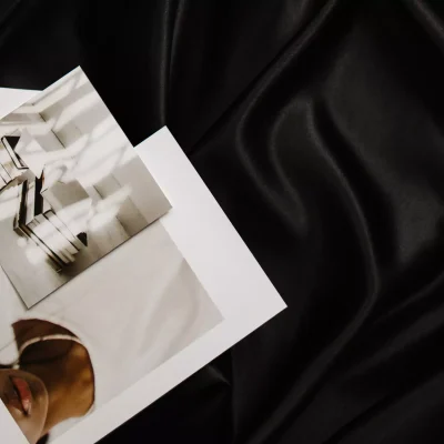 Three photographic postcards resting on black satin fabric