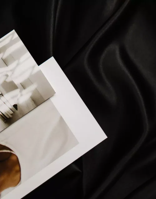 Three photographic postcards resting on black satin fabric