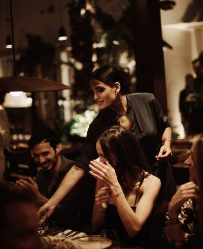 Guests enjoying themselves at a social dinner event in a warmly lit restaurant setting