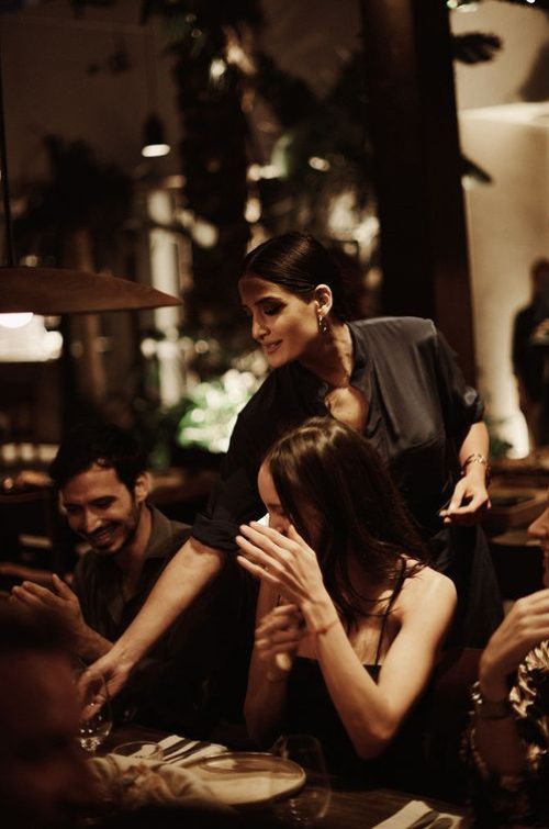 Guests enjoying themselves at a social dinner event in a warmly lit restaurant setting